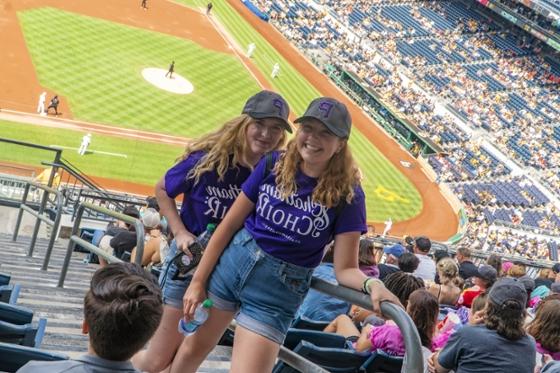  Two female Chatham University choir students in matching purple T-shirts pose together at a Pittsburgh 海盗 game.